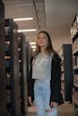 A young woman stands amidst library shelves, capturing the essence of learning.